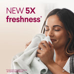 Person smelling a soft towel with text promoting new 5x freshness for the scented bleach