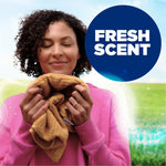 Person inhaling a towel with a bold “Fresh Scent” badge indicating fragrance benefit