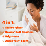 Person holding and smelling a white fabric sheet next to orange copy listing stain-fighter, Downy soft boosters, brightener and scent.