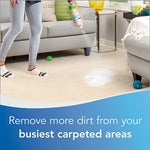Person spraying foam onto a carpeted living room area near a sofa, with product action text about busy carpeted areas.