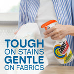 Person spraying a Shout Triple-Acting bottle onto a white garment with text about being gentle on fabrics