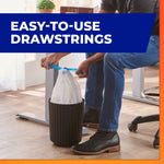 Person tying blue drawstrings on a small trash bag inside a narrow office waste bin with ‘Easy-to-Use Drawstrings’ text