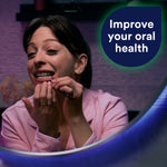 Person using a dental pick in front of a mirror with a DenTek speech-bubble graphic reading 'Improve your oral health'.
