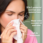 Person holding a Kleenex tissue to their nose with text callouts noting 3-in-1 protection and coconut oil and aloe