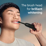 Person using a black Philips Sonicare electric toothbrush handle and brush head with promotional text for whitening.
