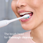 Close-up of a person brushing their lower teeth with a Philips Sonicare brush head on an electric handle