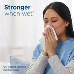 Person holding a tissue to their face with headline text “Stronger when wet” and soft home background