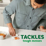 Person wiping a tomato-sauce spill on a countertop with a Bounty paper towel