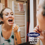 Lifestyle photo of a person with braces using a small interdental brush in front of a bathroom mirror with DenTek logo