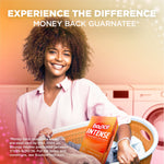 Smiling person holding a laundry basket with a Bounce Intense box visible, laundry room background