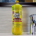 Pine Glo bottle placed on a bathroom counter next to a chrome faucet, showing full front label and yellow cap