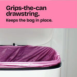 Close view of a pink drawstring trash bag secured inside a white can with text 'Grips-the-can drawstring' on a pink header
