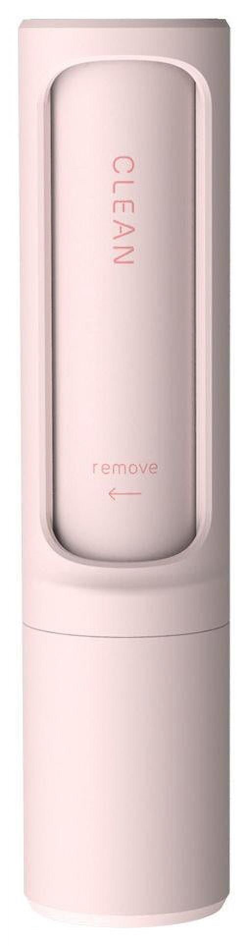 pink handheld lint remover with sliding cover labeled clean and an arrow marked remove