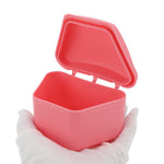 Pink trapezoidal retainer case open, held on a gloved hand showing interior cavity and hinge