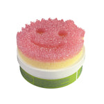 Pink Scrub Mommy smiling sponge sitting on top of a closed Scrub Daddy PowerPaste tub, white background