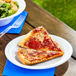Two slices of pepperoni pizza served on a white Great Value foam plate on a wooden table with salad bowl nearby
