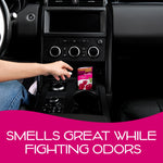 Hand placing a California Scents Coronado Cherry Scent Bloc into a car cupholder and center console area