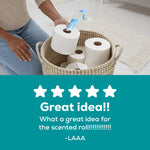Person placing a toilet paper roll into a woven basket with scent ribbons and five-star review text below