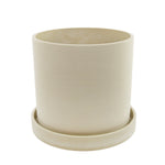Top-down three-quarter view of a cream upcycled planter showing interior and matching saucer, subtle texture visible