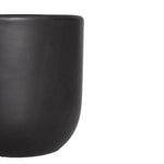 Cropped detail of a semi-matte black clay planter showing the smooth rounded rim and textured surface on white.