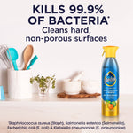 Pledge multisurface cleaner bottle shown on a kitchen counter with text claiming it kills 99.9% of bacteria