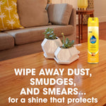 Pledge aerosol can displayed on a polished wood coffee table in a living room scene with succulents and bold product text.