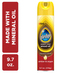 Tall aerosol can of Pledge Expert Care wood oil in yellow-and-red packaging labeled amber & argan scent on white background.