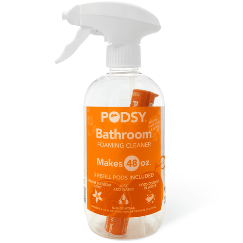 Clear spray bottle labeled PODSY Bathroom foaming cleaner with orange label and visible refill pod inside.