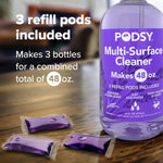 Close-up of Podsy Multi-Surface Cleaner bottle and three purple refill pods on a wooden surface