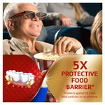 Lifestyle image of a smiling older man eating popcorn with overlay text '5X Protective Food Barrier' and denture illustration.