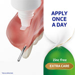 Close-up of adhesive cream being applied to a denture with text panels reading apply once a day and zinc free extra care.