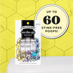 Poo-Pourri on-the-go pack on a toilet cistern with large circular badge stating 'Up to 60 stink-free poops!' on yellow hex wall