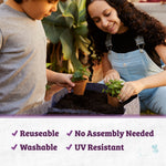 Close-up of two people potting seedlings into a gray fabric grow bag filled with soil, showing reusable fabric texture.