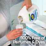 Person pouring all® free clear liquid detergent from a white bottle into a measuring cup over a washing machine