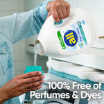 Person pouring clear liquid from an all free clear detergent jug into a measuring cup over a washer