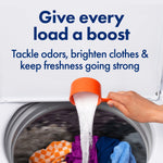 Top-loading washing machine with baking soda being poured from an orange scoop and headline about boosting laundry