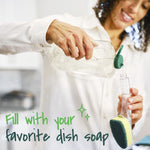 Hands pouring dish soap into the clear handle of a Scotch-Brite dishwand, with handwritten-style text overlay.
