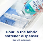 Hand pouring Downy Rinse & Refresh into a washing machine fabric softener dispenser with instructional text below.