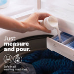 Hand pouring white fabric softener from a measuring cap into a washing machine dispenser with text about measuring and pouring.