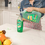 Person pouring green Gain Ultra Clean refill jug into a smaller dish soap bottle on a kitchen counter