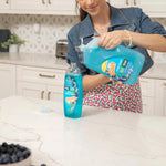 Person pouring Gain Ultra Clean dish soap from a large refill jug into a smaller bottle on a kitchen counter