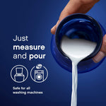 Pouring white liquid from a blue measuring cap with icons for top and front load machines