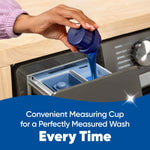 Close-up of a hand pouring blue liquid from a measuring cap into a washing machine dispenser with caption about a convenient cup.