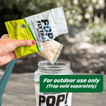 Pouring the water-soluble pouch from a RESCUE! POP! Fly Trap refill into an open trap jar outdoors with overlay text