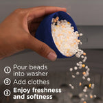 Hand pouring white and pale orange scent booster beads from a blue measuring cap into a washer, with usage step text overlay.