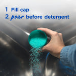 Hand pouring turquoise scent crystals from a green cap into a washing machine with usage instruction text overlay