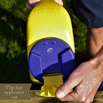 Close-up of a hand opening the flip-top applicator cap on a yellow Preen weed preventer container