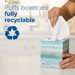 Hand pulling a tissue from a patterned Puffs box with text declaring ‘Puffs boxes are fully recyclable’ and recycling icon