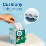 Puffs Plus Lotion cube box on a surface with a hand pulling a tissue and an inset showing cushiony thickness cross-section