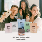 Group lifestyle scene with three people smiling behind an array of pul product pouches and an aligner case with tool on table.